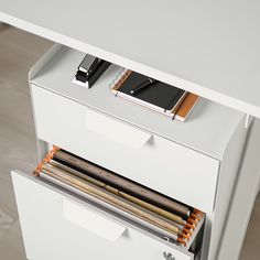 an office desk with two drawers and a notepad on top of the file cabinet