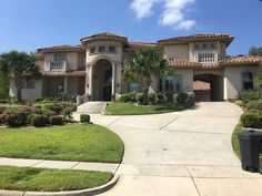 a large house with palm trees in the front yard