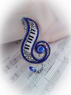 a close up of a musical instrument on top of sheet music with blue and white beads