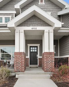 the front entrance to a home with gray siding and white trim