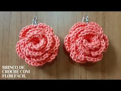 two crocheted flower earrings are shown on a wooden surface with the words, brico de crochet com flor facil