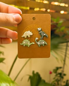 a person holding up a small card with two dinosaurs on it