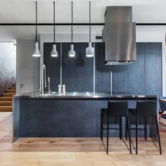 a modern kitchen with an island and bar stools