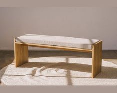 a wooden bench sitting on top of a white rug