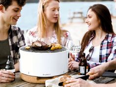 four people sitting around a table with food and drinks