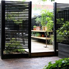 an open door to a garden with potted plants