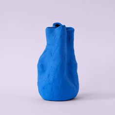 a blue vase sitting on top of a white table