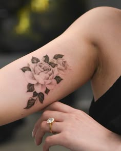 a woman with a rose tattoo on her arm