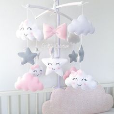 a baby crib mobile with stars and clouds hanging from it's sides,