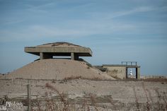 an old concrete structure sitting on top of a pile of dirt in the middle of nowhere