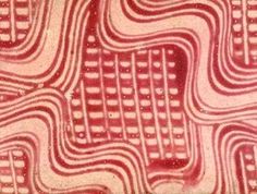 an image of red and white patterns on the surface of a piece of art that looks like it has been made out of paper