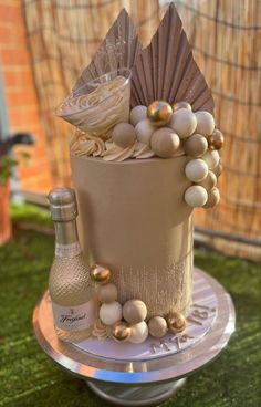 there is a cake that has been decorated with pearls and wine bottles on the table