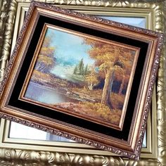 a painting hanging on the wall above a window in a room with gold trimming