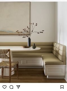 a room with a table, bench and vase on the wall next to a painting