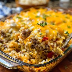 a casserole dish with sausage and rice being lifted from the casserole