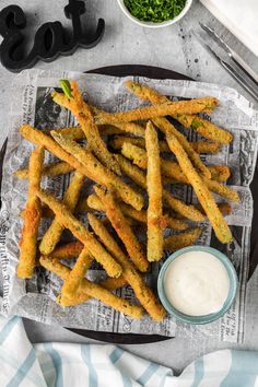 french fries on a plate with dipping sauce next to it and a bowl of ranch dressing