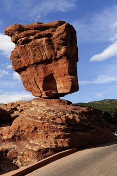 a large rock sitting on the side of a road