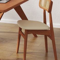 a wooden desk with a laptop on top of it and a chair next to it