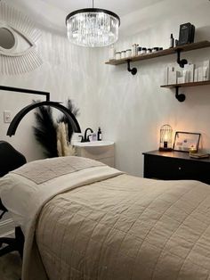 a bedroom with a bed, desk and two shelves on the wall next to it