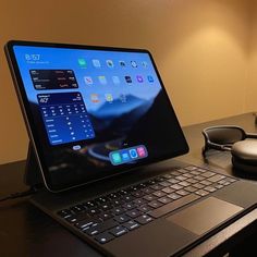 an open laptop computer sitting on top of a wooden desk