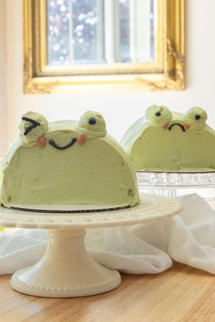 two cakes with green frosting and faces on them