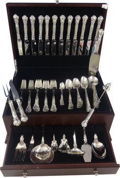 an assortment of silverware in a wooden case