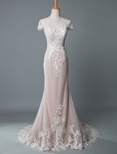 a wedding dress on a mannequin with white lace and beadings,