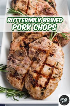 grilled pork chops on a white plate with rosemary garnish