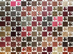 a quilt made with many different colors and patterns on it's sides, including the letter