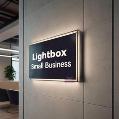 the lightbox small business sign is lit up in front of a meeting room table