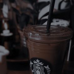 there is a starbucks drink with a straw in the cup and it's brown