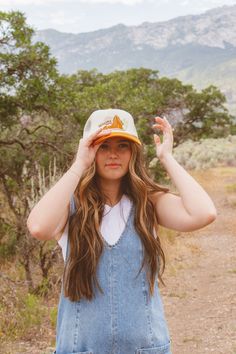 These trucker hats are our new favorites, and they will be yours too! Each style of hat has an adjustable band. Wear them with your hair down or up, and it will instantly make any outfit complete. This hat is white and orange with an adorable, embroidered vintage style Sedona, AZ desert scene on the front Retro Spring Bucket Trucker Hat, Retro Curved Bill Hats For Spring, Orange Baseball Cap For Beach, Retro Baseball Cap For Vacation, Retro Orange Baseball Cap With Curved Brim, White 5-panel Trucker Hat For Summer, Vintage Trucker Hat With Curved Brim For Summer, White Retro Trucker Hat With Curved Brim, Summer Vintage Snapback Hat With Curved Bill