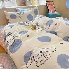 a bed with blue polka dots on it and a white dog print comforter set