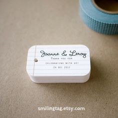 a close up of a small white box with a label on it next to a roll of tape