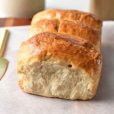 two loaves of bread sitting on top of a piece of paper next to a fork