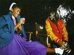 two people dressed in costumes sitting next to each other and one person holding a cup