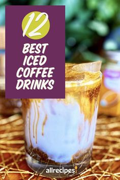 a glass filled with liquid sitting on top of a straw covered table next to a sign that says best iced coffee drinks