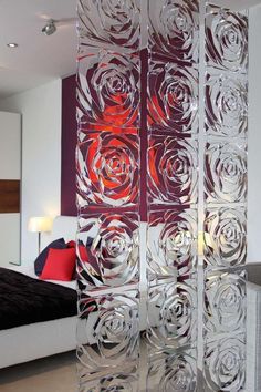 a room divider made out of glass with red roses on the side and white walls