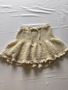 a crocheted skirt is laying on a white sheet with the bottom ruffled