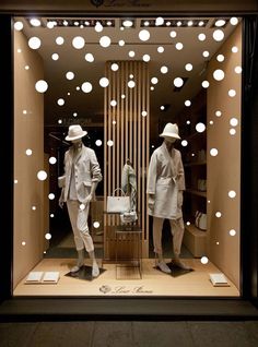 two mannequins dressed in suits and hats are displayed in a store window