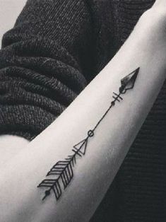 a woman's arm with an arrow tattoo on it