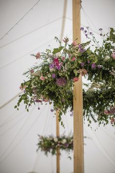 flowers are hanging from poles in the air