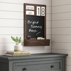 a chalkboard is mounted on the wall above a dresser in a room with white walls