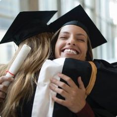 two graduates hugging each other in their caps and gowns