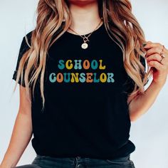 a woman with long hair wearing a black shirt that says school counselor on the front