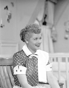 a black and white photo of a woman sitting on a bench