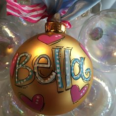 a gold ornament with the word beld painted on it and hearts around it