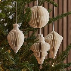 three ornaments hanging from a christmas tree with the words west elm written below one ornament