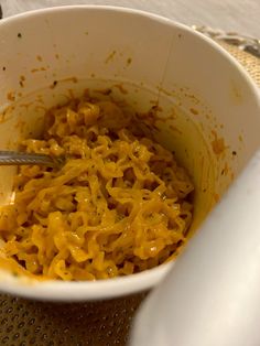 a white bowl filled with macaroni and cheese sitting on top of a table