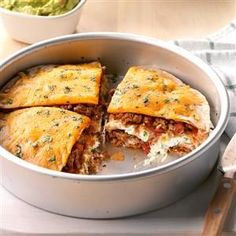 a pan filled with some tasty looking food on top of a table next to utensils